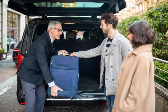 Chauffeur de taxi aidant un passager à charger ses bagages pour un transfert vers l'aéroport de Lille-Lesquin